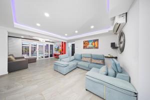 a living room with blue couches and a clock on the wall at Piedra Plat 1 A in Oranjestad