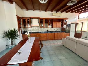 a large kitchen with a wooden table and a couch at Casa Luna in Lipari