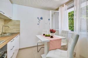 a kitchen with a white table and chairs at Deja near centar and Čikat bay with private parking in Mali Lošinj