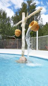a fountain in a swimming pool with two baskets at Mobil Home vue sur le lac dans un camping 4 étoiles à Cadenet in Cadenet