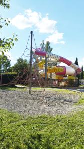 a playground with a slide in a park at Mobil Home vue sur le lac dans un camping 4 étoiles à Cadenet in Cadenet