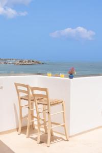 2 Stühle und eine Bar mit Meerblick in der Unterkunft Sea Breeze Hotel in Hersonissos