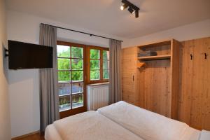 a bedroom with a bed and a large window at SCHETERERHOF in San Candido