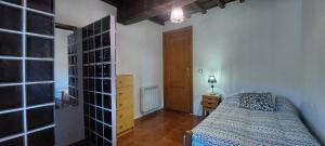 Un dormitorio con una cama y una puerta de madera. en La Casa de Su, en Baños de Montemayor