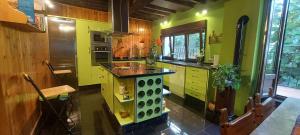 cocina con encimera y paredes amarillas y verdes en La Casa de Su, en Baños de Montemayor