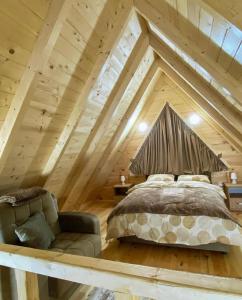 a bedroom with a bed and a couch in a attic at Villa Wood Borje in Žabljak