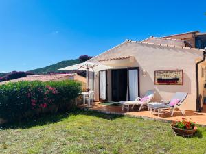 a small white house with chairs and an umbrella at La Casa del Mirto in Palau +35 photos