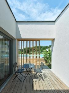 a patio with a table and chairs on a deck at RELAX APARTMENTS An der Lage Hochgraßnitzberg in Spielfeld