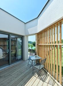 a patio with a table and chairs on a deck at RELAX APARTMENTS Hochgraßnitzberg in Spielfeld