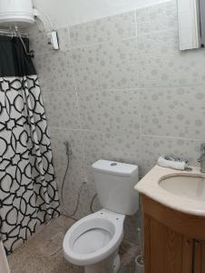a bathroom with a toilet and a sink at Alojamiento in Fray Bentos