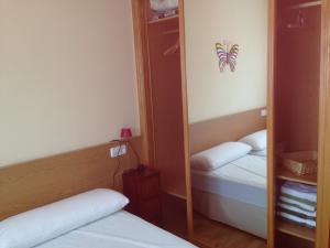 a small room with two beds and a mirror at Apartamento en A revolta in Sanxenxo