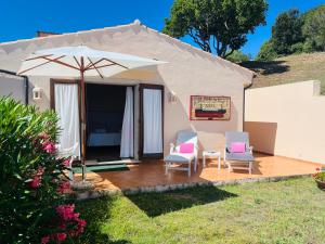 a tent with a table and chairs and an umbrella at La Casa del Mirto in Palau