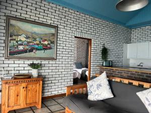 a living room with a couch and a painting on the wall at Blue Whale Resort in George +32 photos