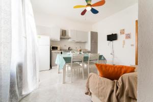 cocina y comedor con mesa y ventilador de techo en Casa Penelope, en Favignana 20 fotos más