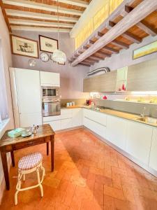 a kitchen with white cabinets and a wooden table at Casa Malò in Pisa