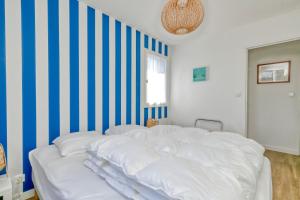 ル・クロワジックにあるPetite maison -の青と白のストライプを用いた客室の白いベッド1台