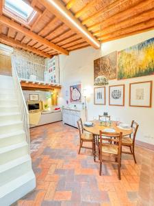 a dining room with a table and chairs and a staircase at Casa Malò in Pisa
