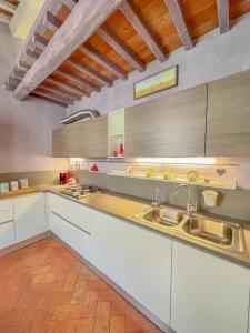 a large kitchen with white cabinets and a sink at Casa Malò in Pisa +10 photos