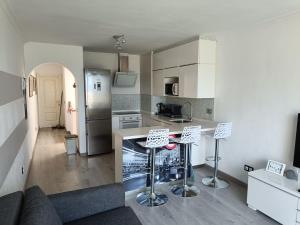 a kitchen with a counter and two bar stools at 100 Steps to the Sand. in La Tejita