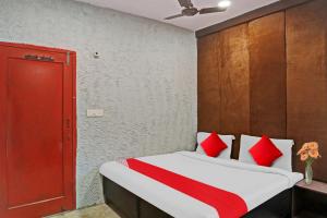 a bedroom with a bed with red and white pillows at Flagship Kashish Residency in New Delhi