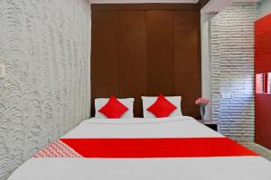 Flagship Kashish Residency في نيودلهي: غرفة نوم بسرير ومخدات حمراء