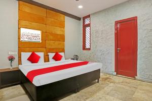 Flagship Kashish Residency في نيودلهي: غرفة نوم بسرير كبير مع باب احمر