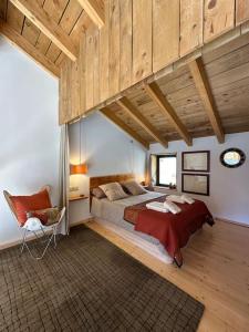 a large bedroom with a large bed and a chair at Moixeró casa en Estavar in Estavar