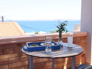 卡法斯的住宿－Chios Shallow Sea，阳台上的桌子上放着两杯酒和托盘