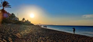 una persona parada en la playa al atardecer en Sunny Denia Apartment 4U - Mar Baltic 5, en Denia