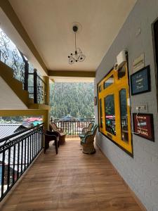 a room with a balcony with a view of a mountain at Pahadirovers Homestay & Cafe in Kasol +45 photos