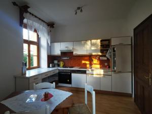 a kitchen with white appliances and a table with chairs at Villa Martiny in Seeboden