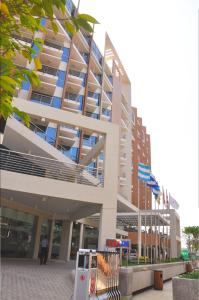 un grand bâtiment avec drapeaux devant lui dans l'établissement Long Beach Hotel, à Cox's Bazar