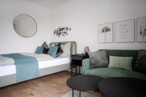 ein Schlafzimmer mit einem Bett, einem Sofa und einem Spiegel in der Unterkunft Relax Apart Bonn in Bonn