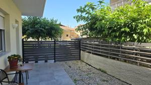 a fence with a table and chairs in front of a building at Zeta - Garden Oasis & Private Parking in Katerini