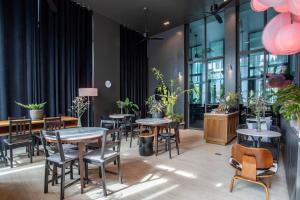 ein Restaurant mit Tischen, Stühlen und Pflanzen in der Unterkunft Two Bedroom Onyx Villa Nai Harn in Nai Harn Beach