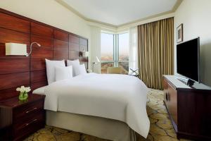 a hotel room with a large bed and a television at Movenpick Makkah Hajar Tower in Makkah