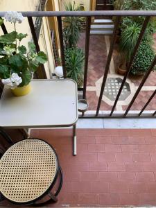 a white table and chair on a balcony with plants at New Flat Between The Vatican & Piazza del Popolo in Rome