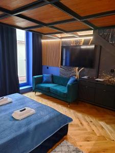 a bedroom with a blue bed and a couch at LUX 114 APARTMENT in Košice