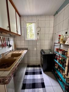 uma pequena cozinha com um lavatório e uma janela em Meri Lodge Huahine (Mamado’s House) em Fare