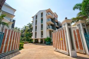 une porte en face d'un bâtiment planté de palmiers dans l'établissement Luxury 2BHK Apartment Near Candolim, à Nerul