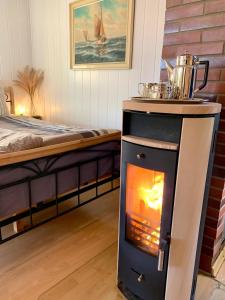 a stove in a room next to a bed at Haus am See mit Kamin in Mecklenburg in Cammin