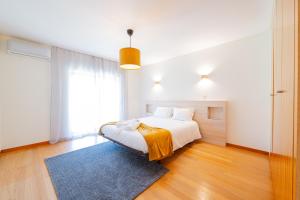 Dormitorio blanco con cama y alfombra azul en Brook House, en Vieira do Minho 9 fotos más
