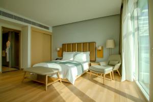 a bedroom with a bed and a table and a chair at Zoya Health & Wellbeing Resort in Ajman 