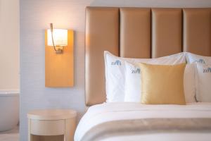 a hotel room with a bed with white pillows at Zoya Health & Wellbeing Resort in Ajman 