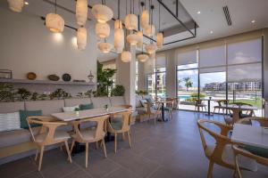 Marassi Boutique Hotel-Marina 1 في العلمين: مطعم بطاولات وكراسي ونوافذ