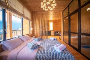 a large bed in a room with a large window at Mountain-view double villa, pet-friendly, ideal for long stays Svaneti Countryside 3 in Mestia