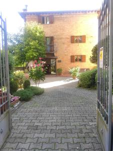 eine offene Tür zu einem Backsteingebäude mit einem Innenhof in der Unterkunft Hotel Arcobaleno Siena in Siena