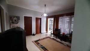 a living room with a couch and a table and a tv at Villa Putih in Songgoriti