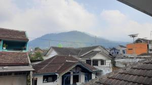 a group of houses with a mountain in the background at Villa Putih in Songgoriti