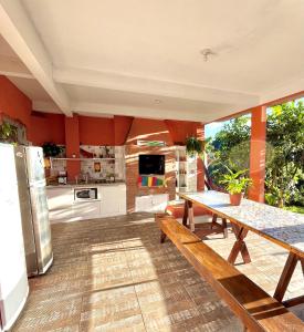 uma grande cozinha com uma mesa de madeira e uma sala de jantar em Vibe House Hostel em Florianópolis